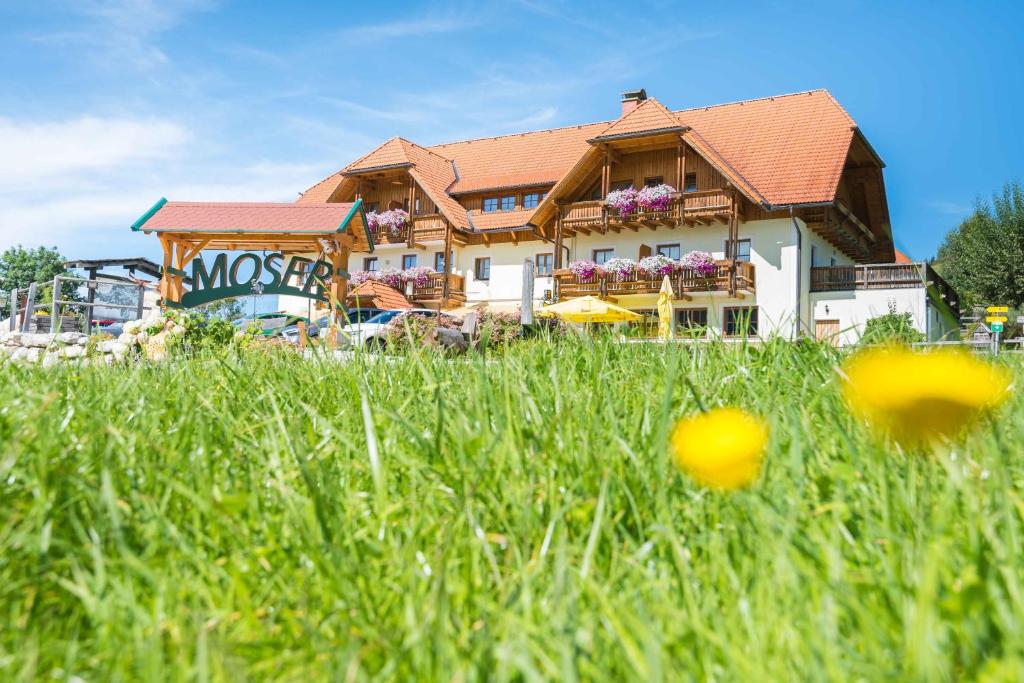 a building with a field of grass in front of it at Alpengasthof Moser in Karchau