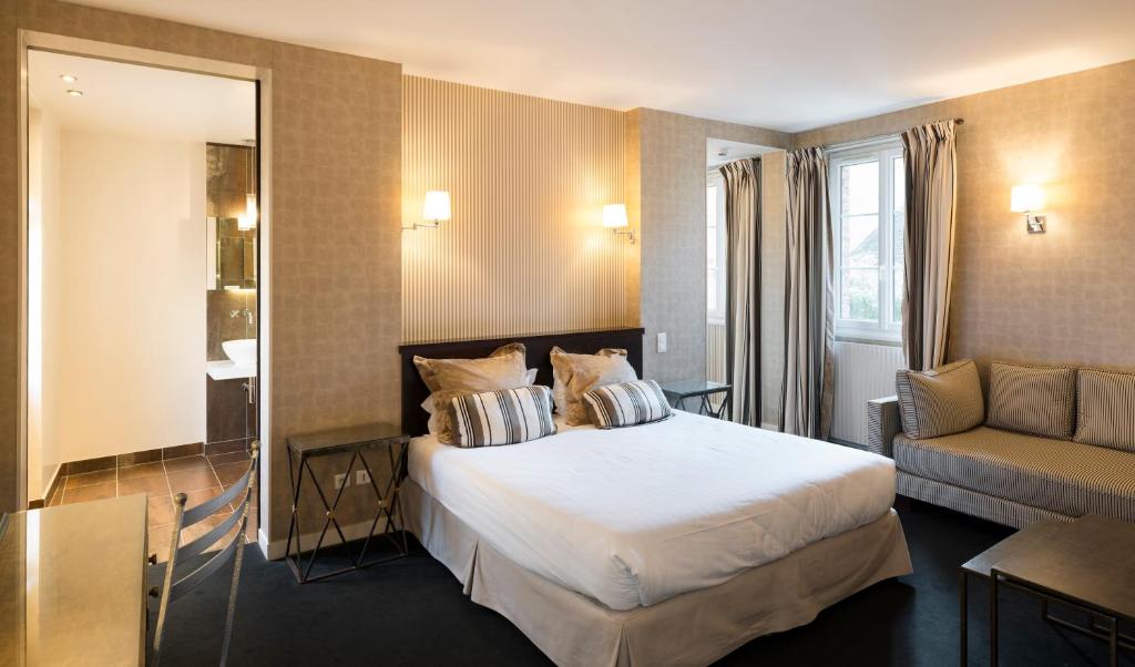Postel nebo postele na pokoji v ubytování Logis - Hôtel & Restaurant du Tribunal