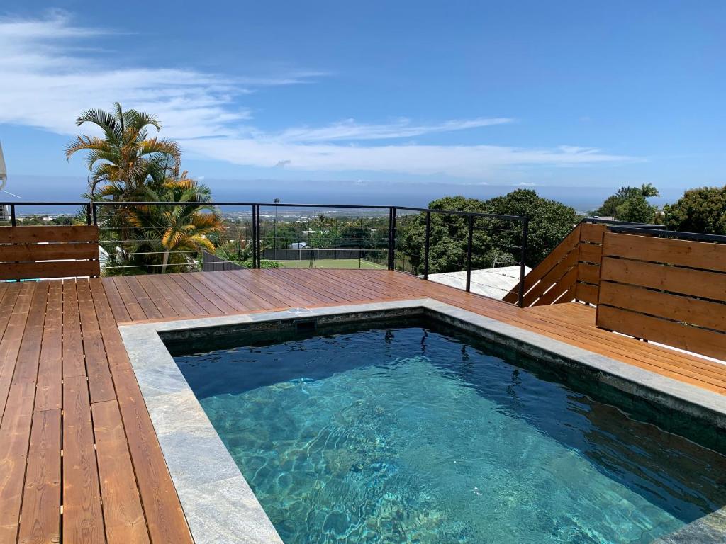 una piscina en una terraza con vistas al océano en Villa Miss Satô en Ravine des Cabris