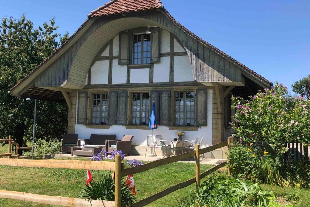 uma pequena casa com um telhado de gambrel em Freistehendes, denkmalgeschütztes Stöckli bei Bern em Kirchlindach