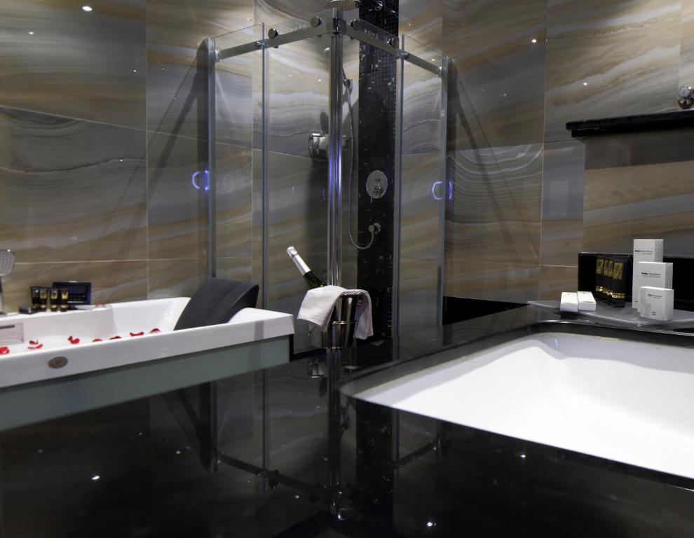 a bathroom with a shower and a sink and a tub at Swiss Flora Royal Hotel Riyadh in Riyadh