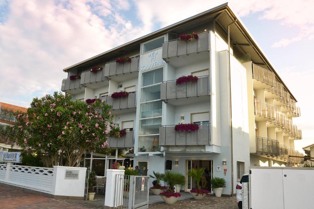 a white building with flower boxes on the balconies at Hotel Souvenir in Cervia
