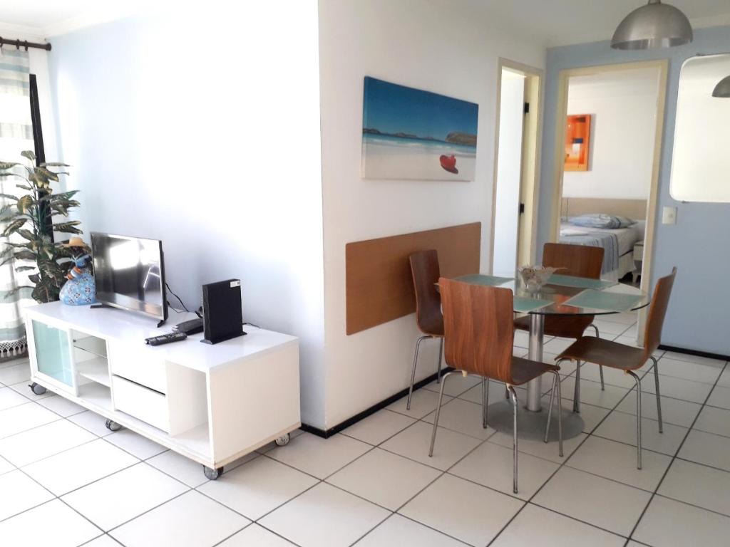 a dining room with a glass table and chairs at Iracema Apartament in Fortaleza