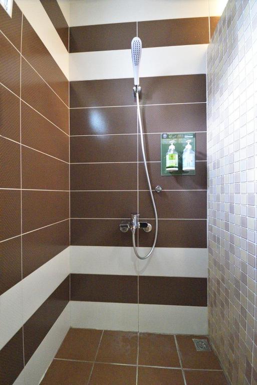 a bathroom with a shower with brown and white stripes at Taitung Venice B&amp;B in Taitung City