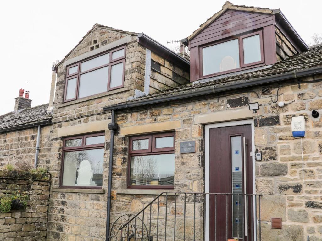 an old stone house with windows and a door at Little Barn in Keighley