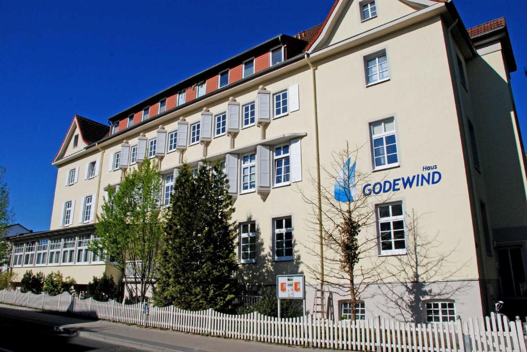 ein Gebäude mit einem weißen Zaun davor in der Unterkunft Ferienwohnung mit Balkon "Charming Holidays" in Binz