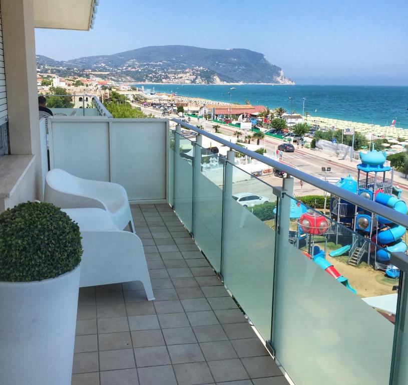 a balcony with a view of a beach and the ocean at Emozione Marina - appartamento fronte mare in Marcelli