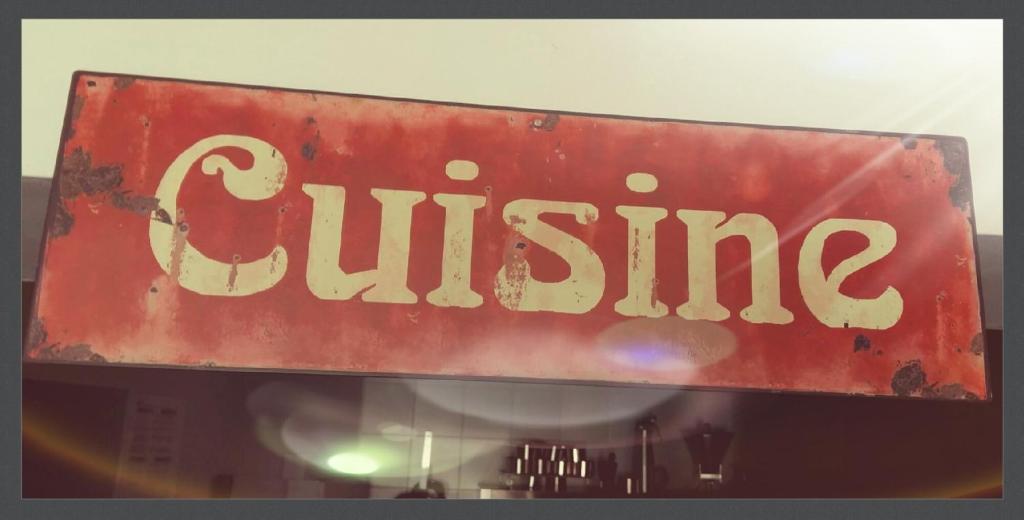 a red sign with the word cuisine on it at Hotel La Peyrade in Cajarc