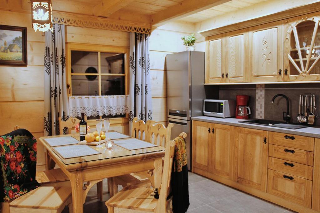 a kitchen with a wooden table and a refrigerator at BIAŁY PUCH in Zakopane