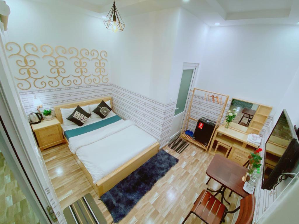 Habitación pequeña con cama y escritorio. en Dalat Hills Hotel, en Da Lat