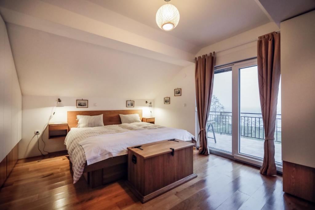a bedroom with a bed and a large window at Rural House Veranda in Šarengrad