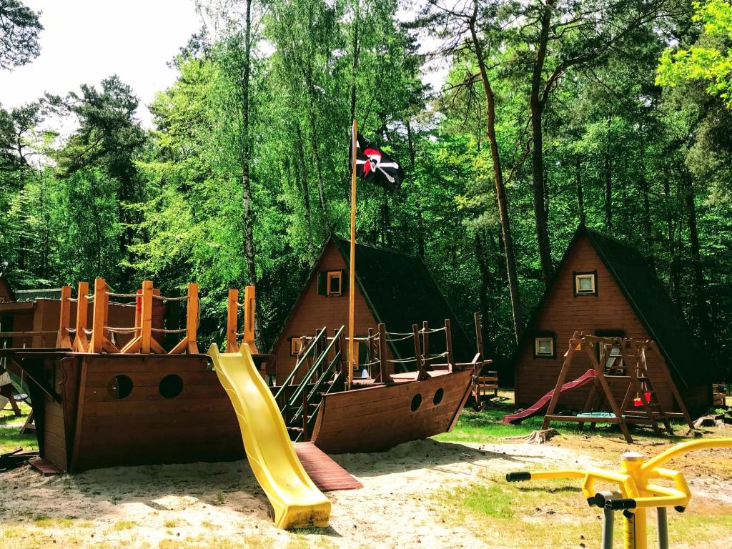 a playground with a slide and a pirate ship at Domki Letniskowe MAJA in Pogorzelica