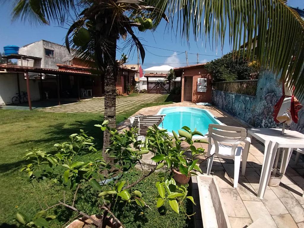 a backyard with a pool and a table and chairs at Pousada Céu de Tucuns in Búzios
