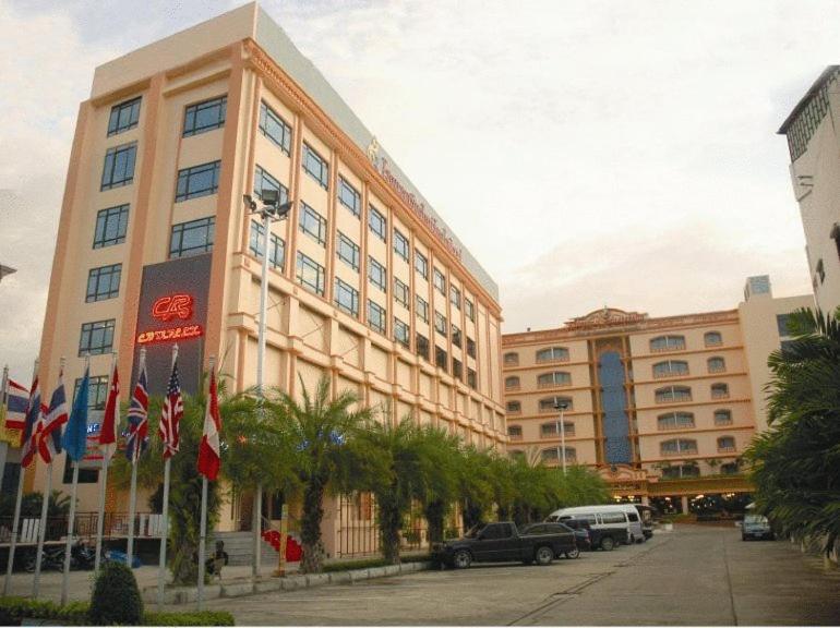 a large building with cars parked in front of it at Chiangmai Ratanakosin Hotel in Chiang Mai