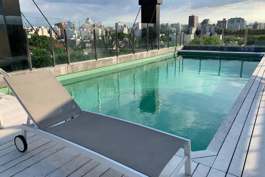 a chair sitting on a deck next to a swimming pool at Amazing apartment with amenities in Buenos Aires
