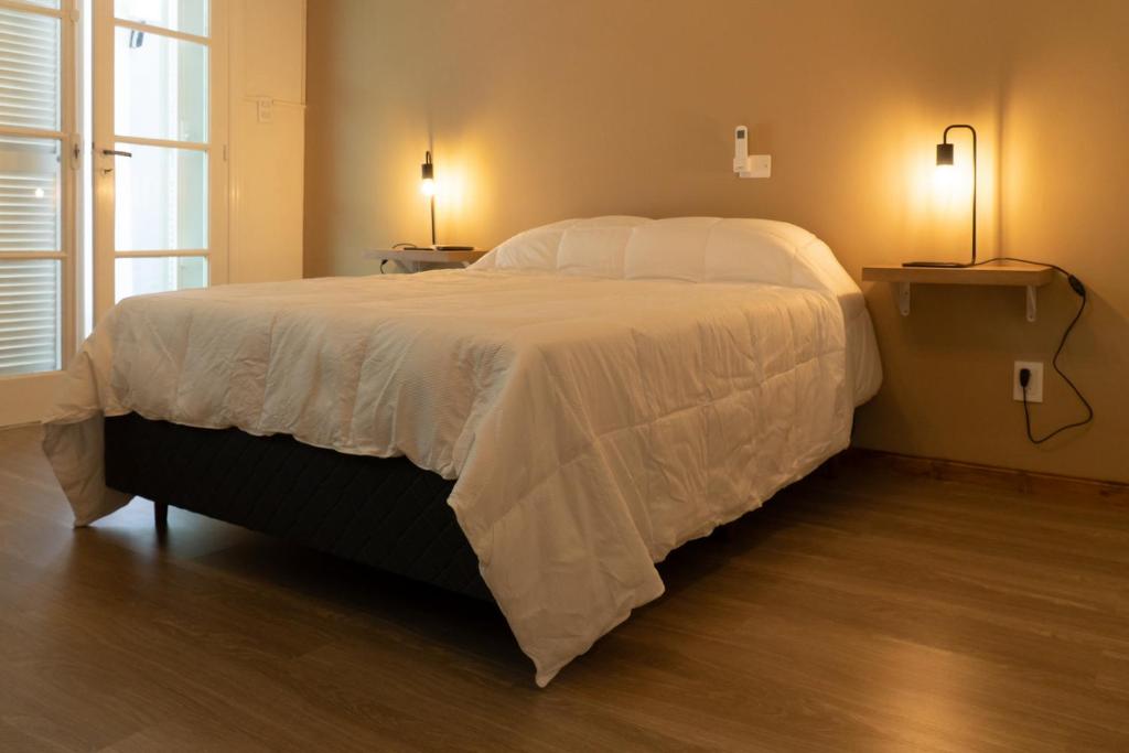 a bedroom with a large bed with white sheets at Habitación en La Casa de Mis Padres in Mendoza