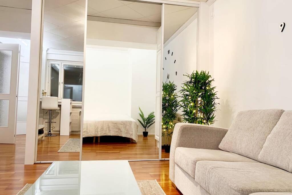 a living room with a couch and a mirror at City Pearl in Jyväskylä