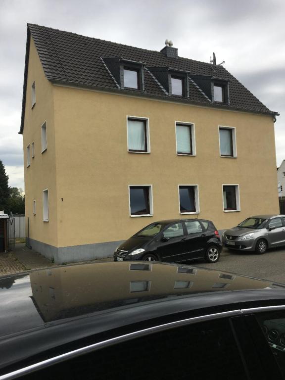 a building with two cars parked in front of it at Monteurwohnung in Rommerskirchen in Rommerskirchen