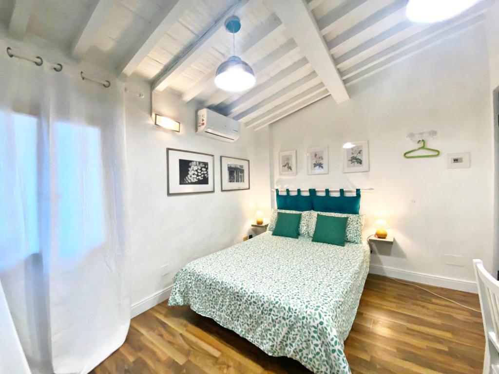 Schlafzimmer mit einem Bett mit grüner Tagesdecke in der Unterkunft Santo Spirito Suite in Florenz