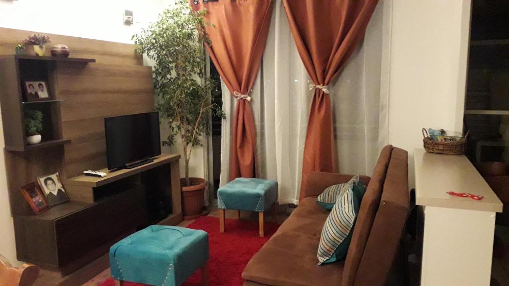 sala de estar con sofá y TV en Apartamento Reinos Francos 414, en La Serena
