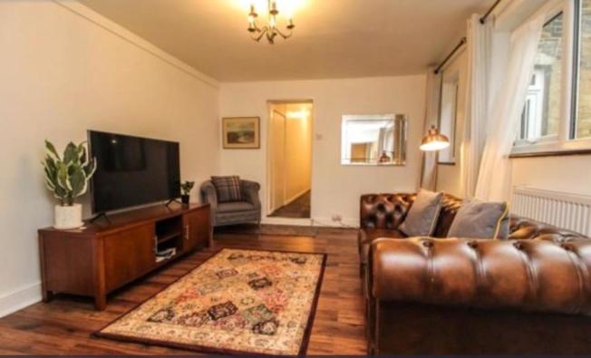 sala de estar con sofá y TV en Charming Victoria Conversion Flat in Brentwood with a Garden & Free Parking en Brentwood