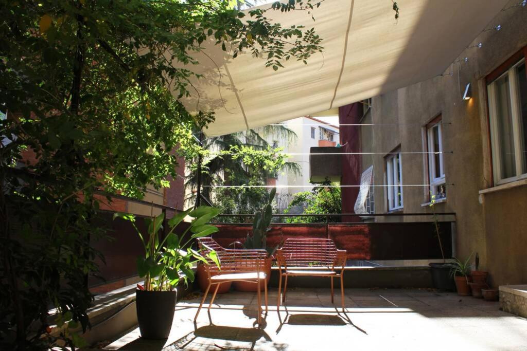 zwei Stühle auf einer Terrasse neben einem Gebäude in der Unterkunft LOQUAT HOUSE nel giardino segreto in zona Vaticano in Rom