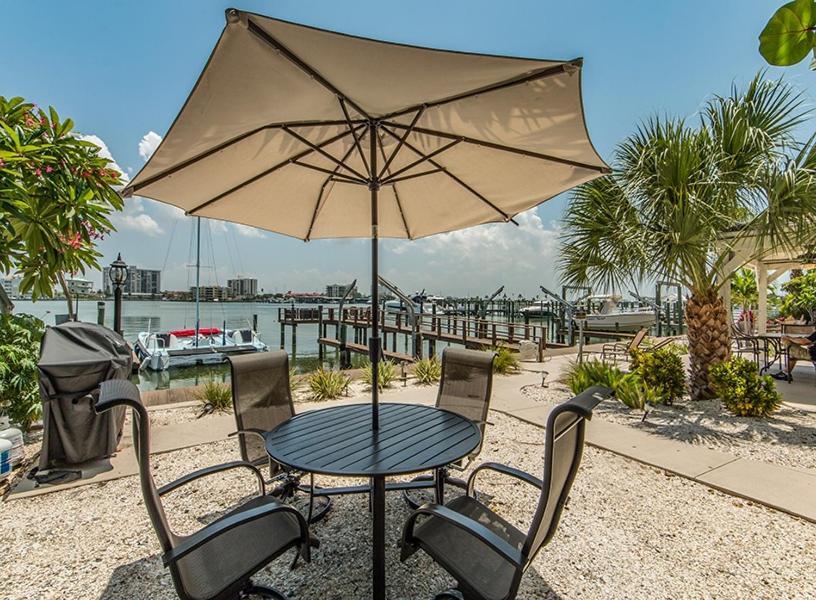 - une table et des chaises avec un parasol sur la plage dans l'établissement Sun Harbor Unit 1 - Weekly Rental townhouse, à Clearwater Beach