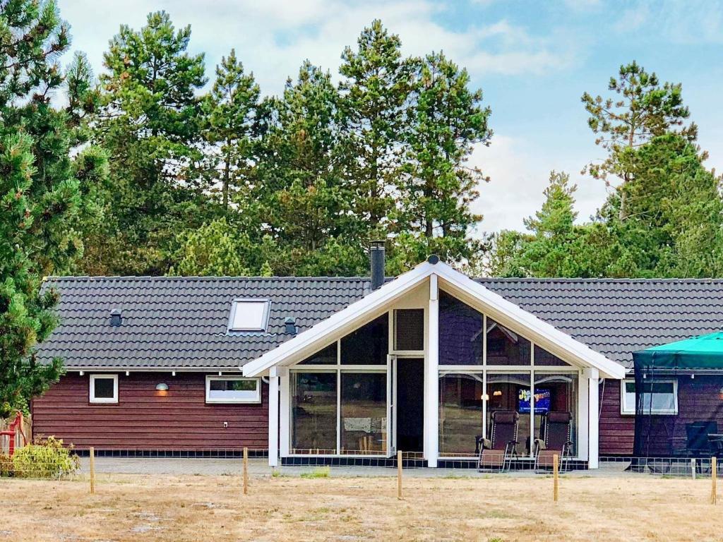 ein Haus mit einer großen abgeschirmten Veranda in der Unterkunft Two-Bedroom Holiday home in Hornbæk 2 in Rødby