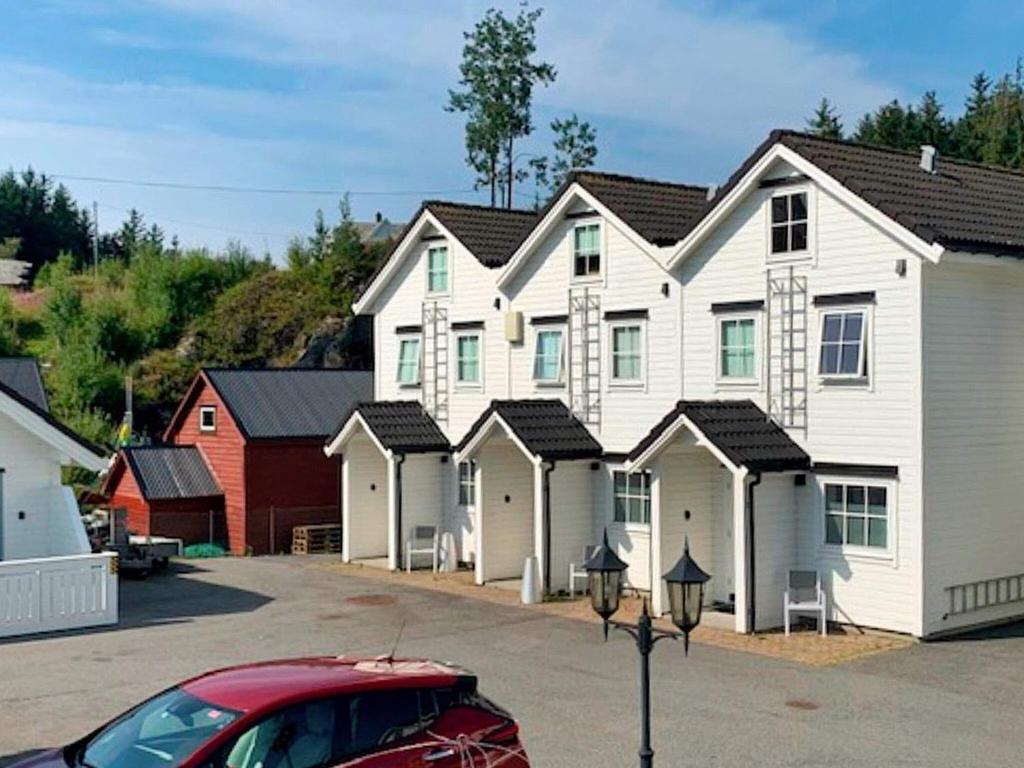 a large white house with a row of houses at 6 person holiday home in Austrheim in Utkeila