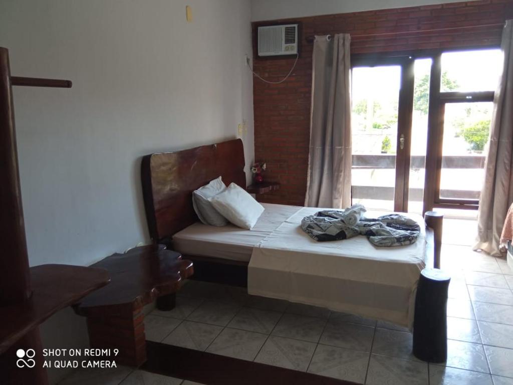 a bedroom with a bed with towels on it at Pousada Kantuta in Mucuri