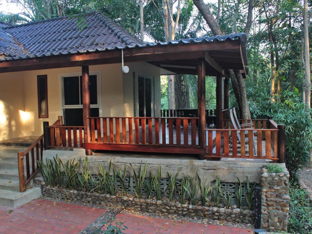 Baan Maka Nature Lodge في كانغ كاتشان: منزل صغير مع شرفة خشبية