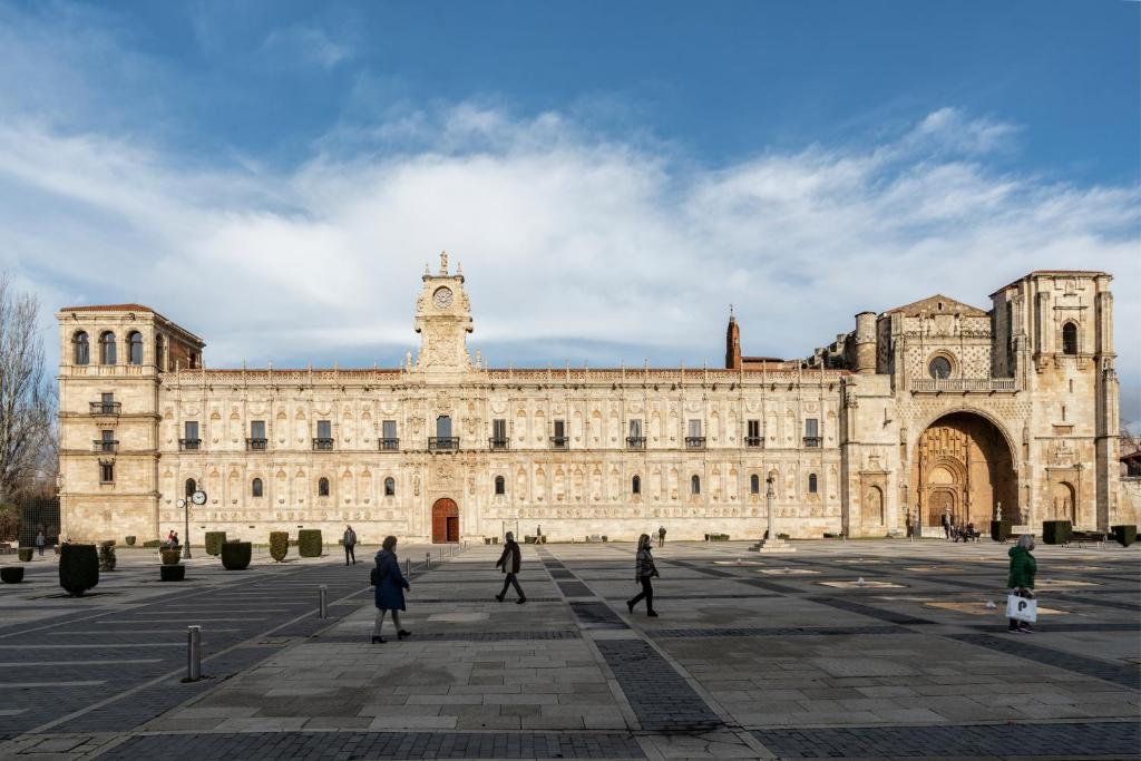 un grande edificio con persone che camminano davanti di Parador de Turismo de León a León