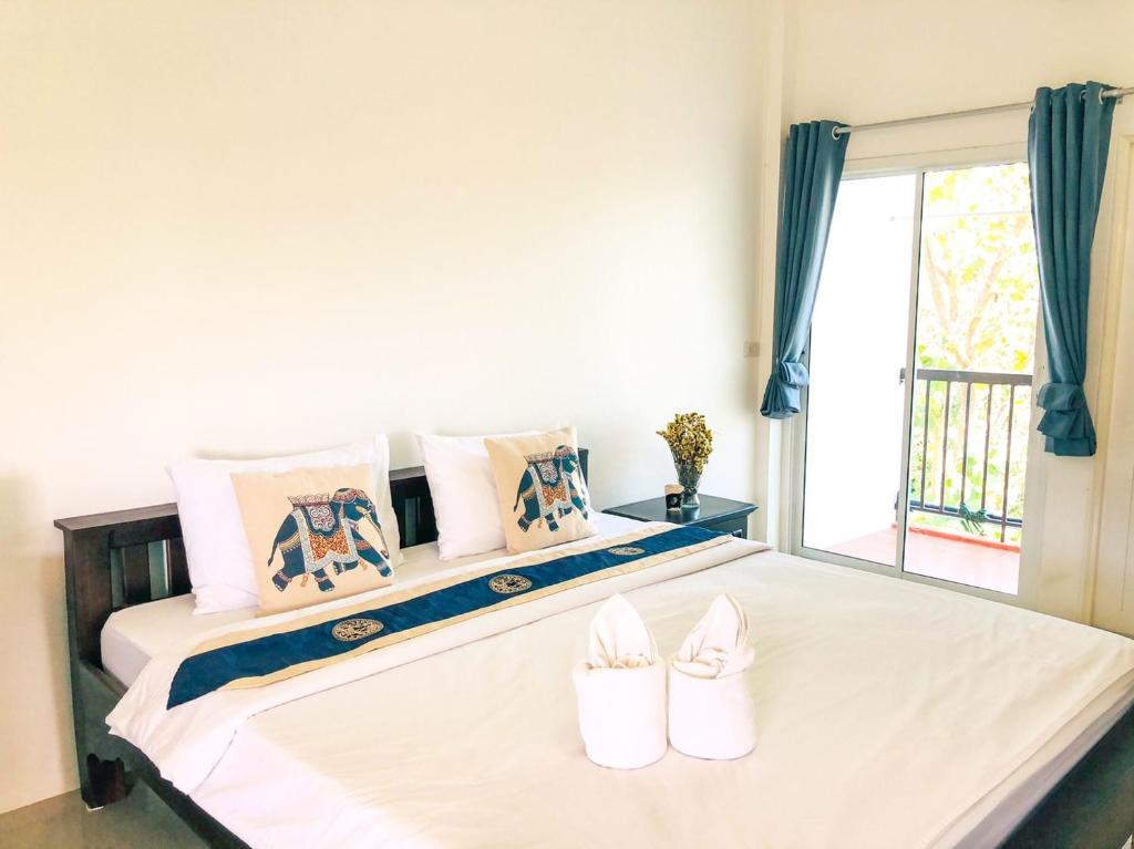 Un dormitorio con una cama con zapatos. en Baanlugchange Hotel en Chanthaburi