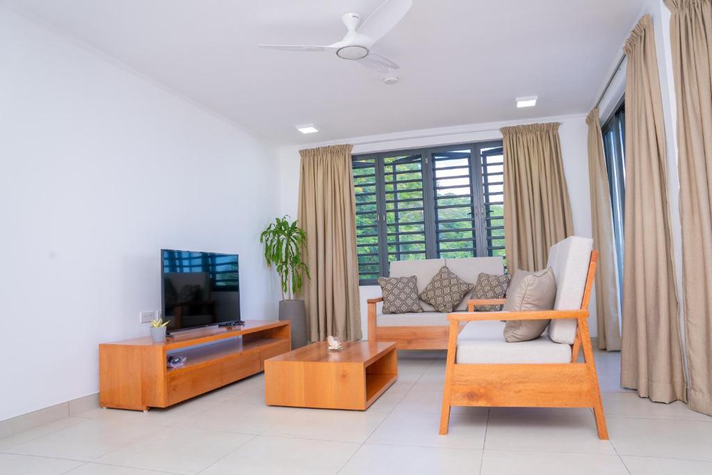 a living room with a couch and a tv at Kolibri Holiday Apartments in Victoria