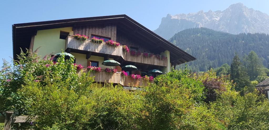 Ein Gebäude mit einem Blumenstrauß auf dem Balkon in der Unterkunft Gästehaus Schoeneweiß in Ehrwald