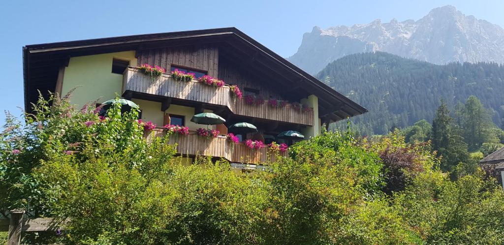 un bâtiment avec un bouquet de fleurs sur le balcon dans l'établissement Gästehaus Schoeneweiß, à Ehrwald