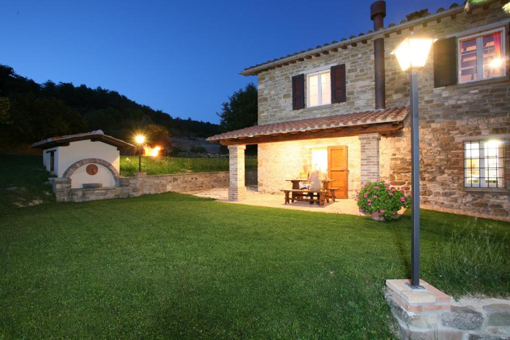 a stone house with a yard at night at Agriturismo Caiburroni in Pietralunga