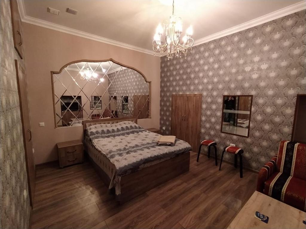 a bedroom with a large bed and a chandelier at apartament oriental tale in old cyti Baku in Baku