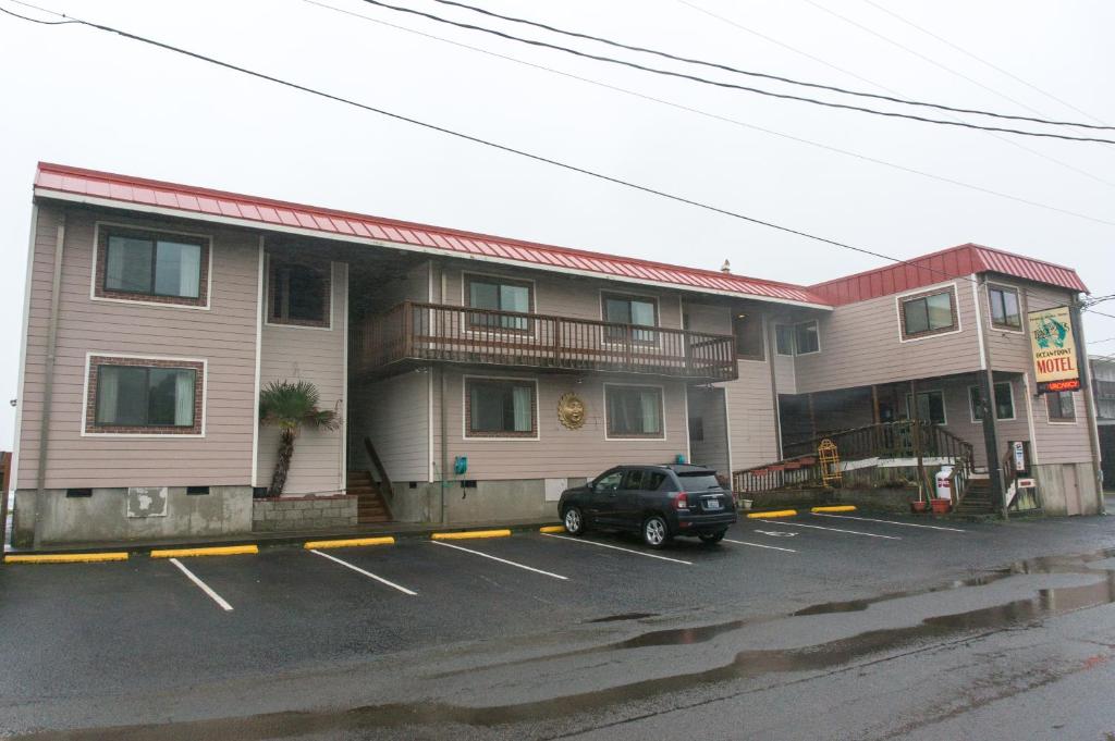 a car parked in a parking lot in front of a building at Tradewinds Motel in Rockaway Beach