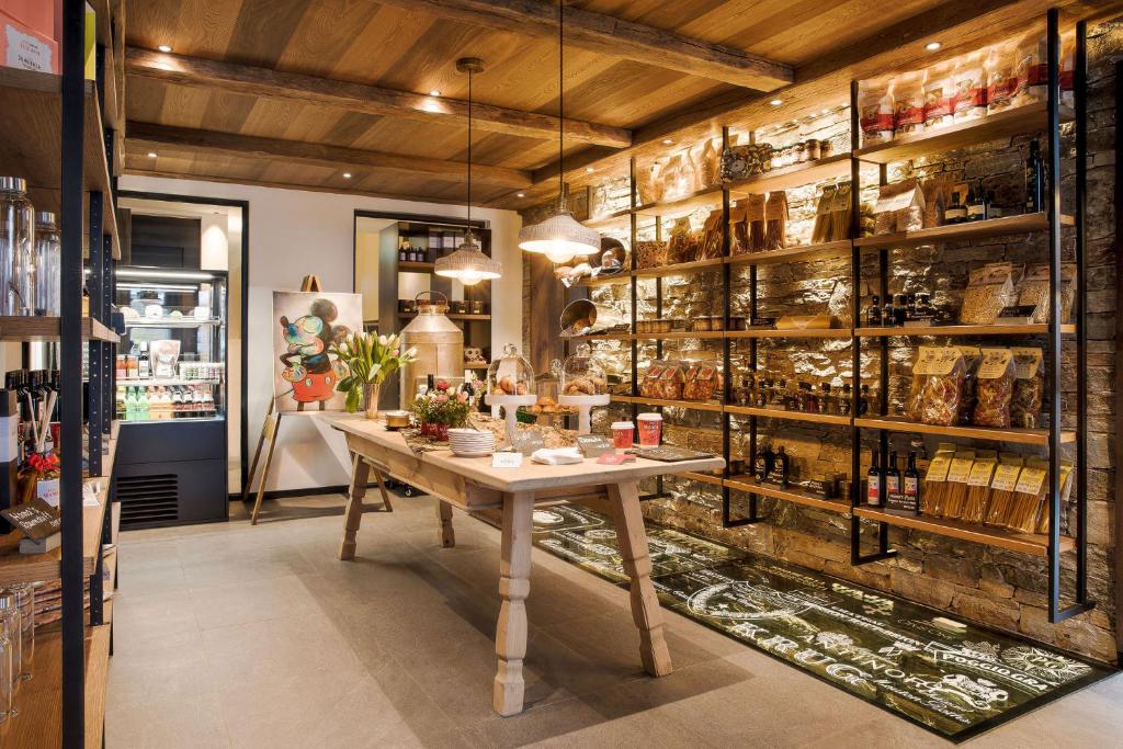 a room with a table and shelves of wine bottles at Hotel ZERMAMA Zermatt in Zermatt