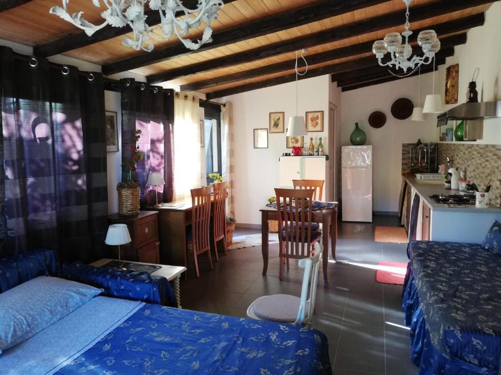 um quarto com uma cama e uma cozinha com uma mesa em Casa della Quercia em San Giovanni la Punta