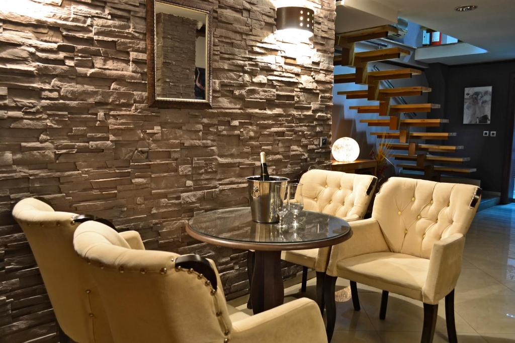 a dining room with a table and chairs and a brick wall at Domus Aparthotel in Skopje