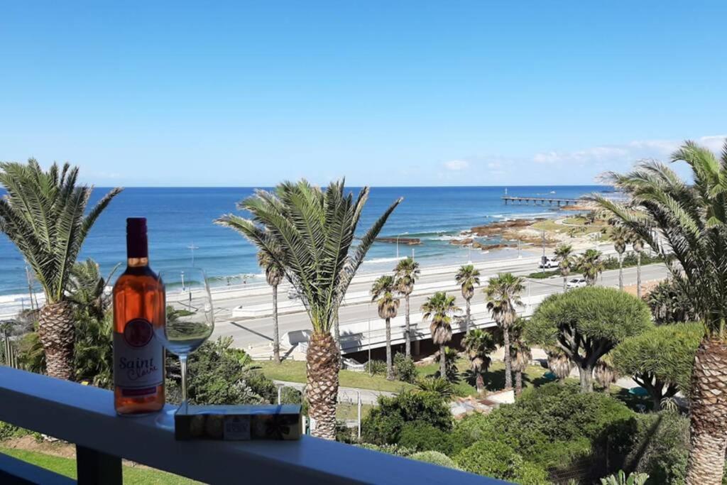 - une bouteille de vin assise sur un balcon donnant sur la plage dans l'établissement Blue views at Brookes Hill Suites, à Port Elizabeth