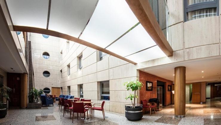 a lobby with tables and chairs in a building at Torreluz Senior in Almería