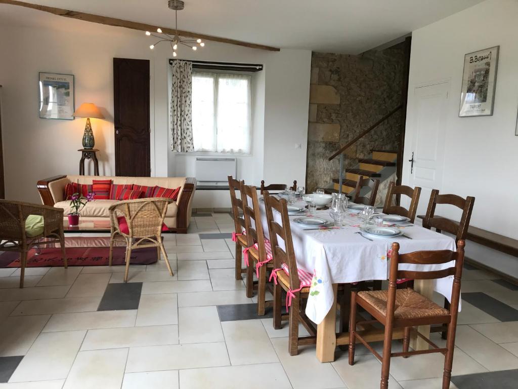 - une salle à manger avec une table, des chaises et un canapé dans l'établissement La grange du Logis du Plessis, à Chaniers