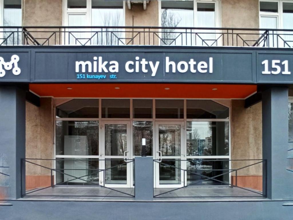 
a building with a sign on the front of it at Mika City Hotel in Almaty
