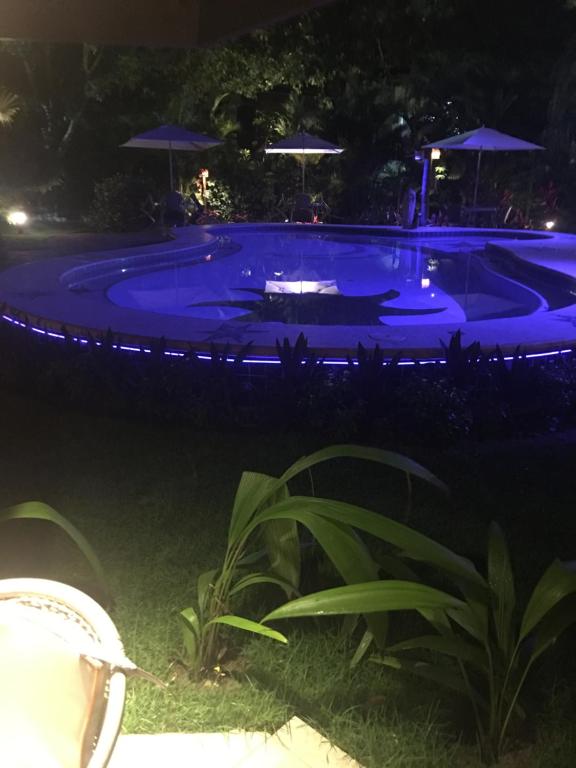 a swimming pool at night with blue lights at Vilarejo do farol in Praia do Forte