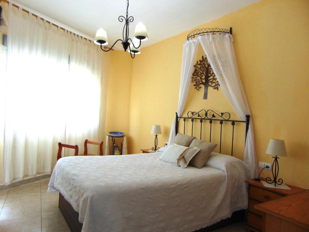 um quarto com uma cama com lençóis brancos e uma janela em Casa Rural El Boyo em Mingorría