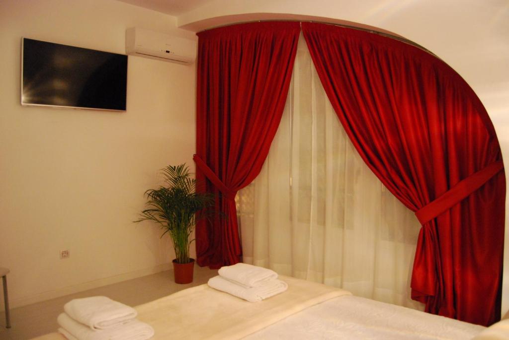 - une chambre avec un rideau rouge et une fenêtre dans l'établissement Hostal PETITE MAMAN, à Madrid