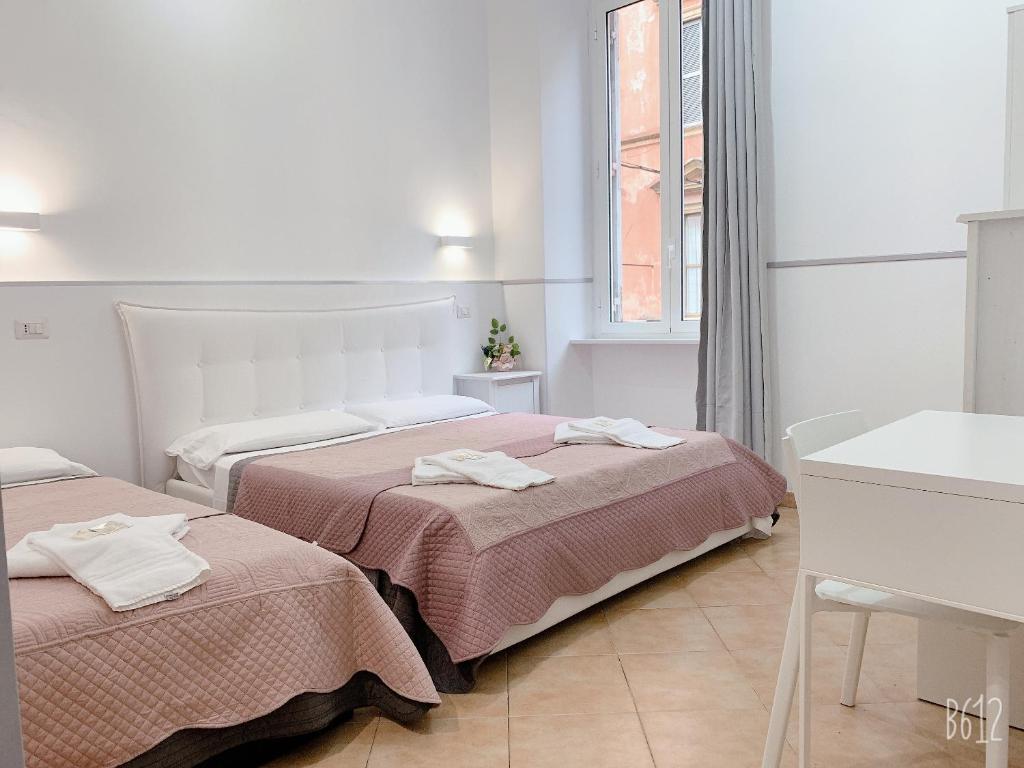 a bedroom with two beds and a table and a window at Golden Ratio in Rome